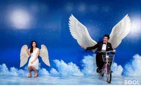 남녀 모델이 트릭아이미술관의 대표작품인 천사날개 앞에서 포즈를 취하고 있다. 