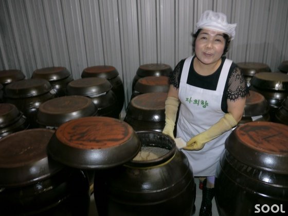 노영희 대표가 오지 항아리에서 익어가는 술을 살펴 보고 있다.