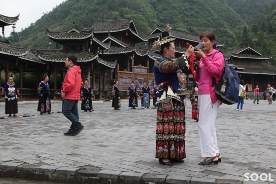마을 입구에서 손님들을 술로 환영하다
