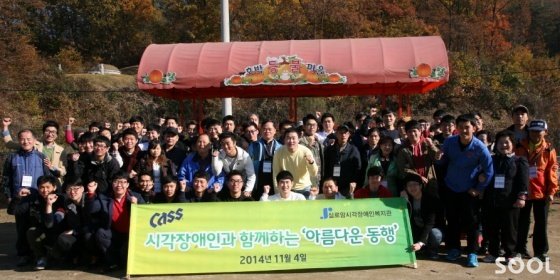 오비맥주는 4일 경기도 용인시 일대에서 ‘시각장애인과 함께하는 아름다운 동행’ 행사를 실시했다. 행사에 참여한 회사 임직원과 실로암시각장애인복지관 회원 등 80여 명이 호박등불마을에서 기념사진을 찍고 있다.