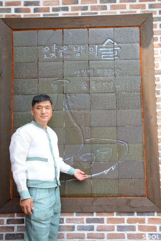 소곡주의 대명사 &lsquo;앉은뱅이 술&rsquo; 앞에서 소곡주를 설명하고 있는 나장연 사장.
