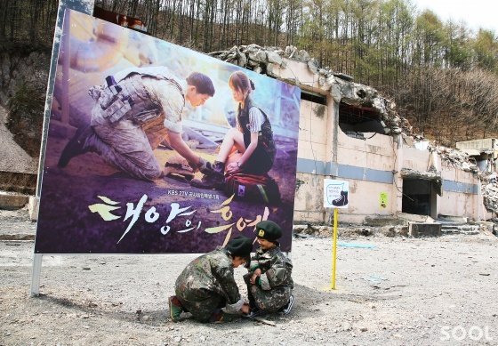 태백 구 한보광업소 1 광구에서 포스터를 따라 어린이들이 신발끈을 묶어주고 있다