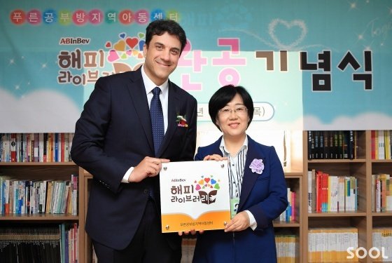3일 오후 서울 영등포구 &lsquo;푸른공부방지역아동센터&rsquo;에서 열린 오비맥주&lsquo;해피 라이브러리&rsquo; 1호 완공 기념식에서오비맥주 김도훈 사장 (왼쪽)과 푸른공부방 지역아동센터 이정순 센터장 (오른쪽)이 현판식에 앞서 기념 촬영을 하고 있다.
