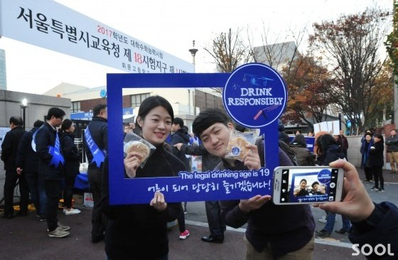 오비맥주 임직원들이 2017학년도 대학수학능력시험일인 17일 저녁 서울 강남구 일대 수능시험장 부근에서 청소년 음주예방 캠페인을 벌였다. &lsquo;SNS 인증 청소년 금주 서약&rsquo;에 참여한 수험생들이 금주 다짐 슬로건이 적힌 피켓을 들고 금주 서약 및 SNS 인증을 하고 있다.