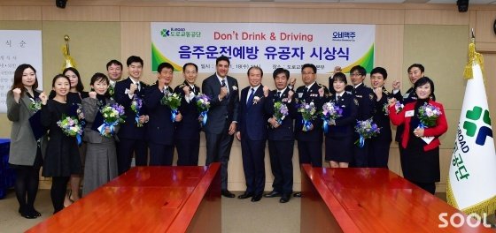김도훈 오비맥주 대표(왼쪽 아홉 번째)와 신용선 도로교통공단 이사장(왼쪽 열 번째)이 18일 오전 강원도 원주시 도로교통공단 본부에서 개최된 ‘제1회 음주운전 예방 유공자 시상식’에 참석해 표창을 수상한 단속 경찰관 및 관계 기관 공무원 15명과 함께 기념촬영을 하고 있다.