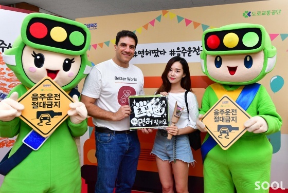 오비맥주가 21일 도로교통공단과 함께 서울 강남운전면허시험장에서 신규 운전면허취득자를 대상으로 음주운전 예방 캠페인을 펼쳤다. 오비맥주 김도훈 대표(왼쪽)와 신규 운전면허 취득자(오른쪽)가 ‘오늘 면허 땄어요’ 문구가 적힌 보드판을 들고 기념촬영을 하고 있다.