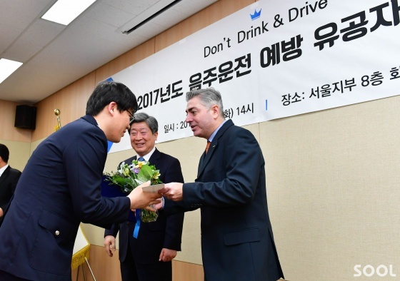오비맥주는 27일 도로교통공단과 함께 건전음주 캠페인의 일환으로 음주운전 예방과 단속에 남다른 공을 세운 경찰관 등을 선정해 포상했다. 오비맥주 브루노 코센티노 대표가 경찰관에게 꽃과 시상금을 수여하고 있다.