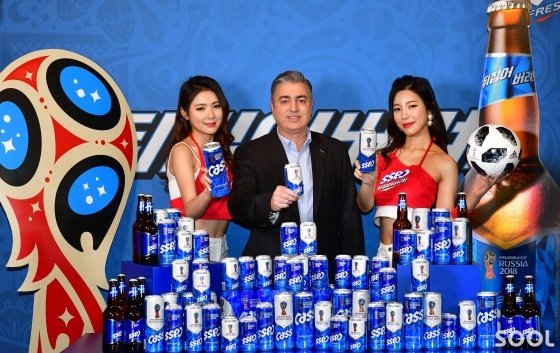 오비맥주 고동우 대표(가운데)와 카스 모델들이 2018 러시아 월드컵에서 한국팀의 선전을 기원하며 ‘뒤집어버려’의 메시지를 담은 ‘카스 후레쉬 월드컵 스페셜 패키지’와 함께 기념 촬영을 하고 있다.
