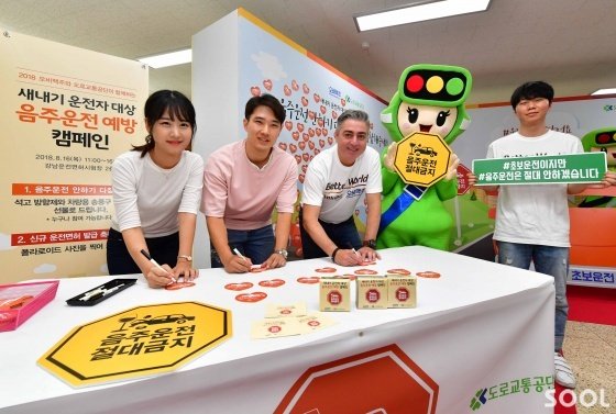 오비맥주가 16일 도로교통공단과 함께 서울 강남운전면허시험장에서 신규 운전면허 취득자를 대상으로 음주운전 예방 캠페인을 펼쳤다. 오비맥주 고동우 대표(왼쪽에서 세 번째)와 신규 운전면허 취득자들이&lsquo;음주운전 안하기 다짐 서약 스티커&rsquo;에 서명을 하고 있다.